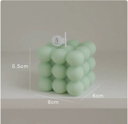 Green bubble candle with measurements on a neutral background