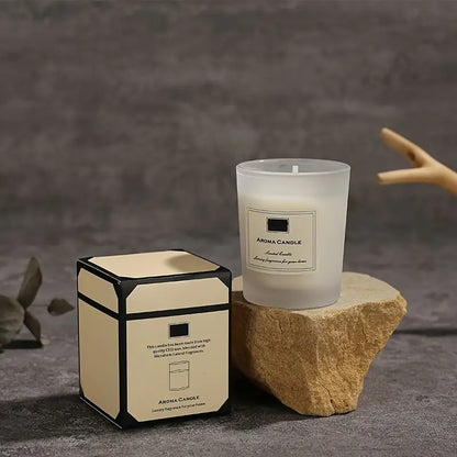 Aroma candle and its packaging on a stone surface with a blurred background