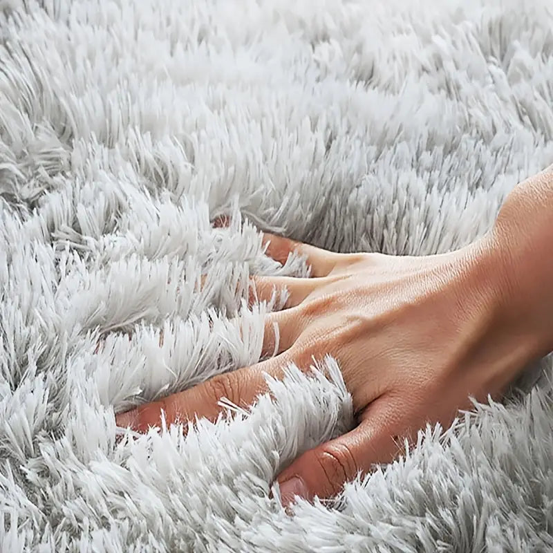 Hand resting on a fluffy white carpet