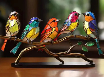 Colorful stained glass birds on a branch with a blurred background