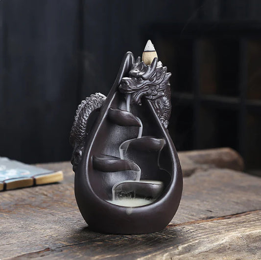 Dragon-shaped backflow incense burner on a wooden surface with a blurred background