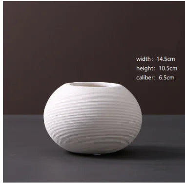 White ceramic vase on a dark surface with measurements displayed.