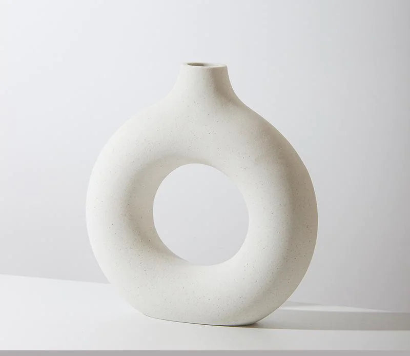 White ceramic vase with circular design on a white background