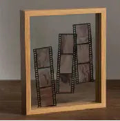 Wooden photo frame with multiple small photo slots on a wooden surface