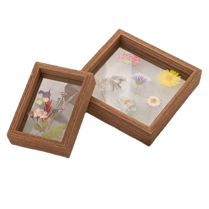 Two wooden boxes with pressed flowers inside on a white background