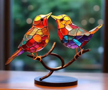 Colorful stained glass birds on a branch against a blurred background