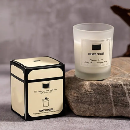 Scented candle and its packaging on a stone surface with a neutral background