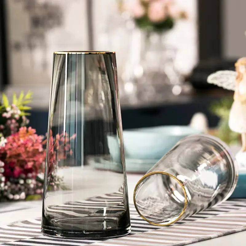 Clear glass vase with a textured design on a striped surface with blurred background
