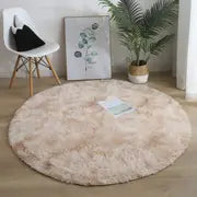 Round beige rug in a room with a plant and framed picture on the wall.