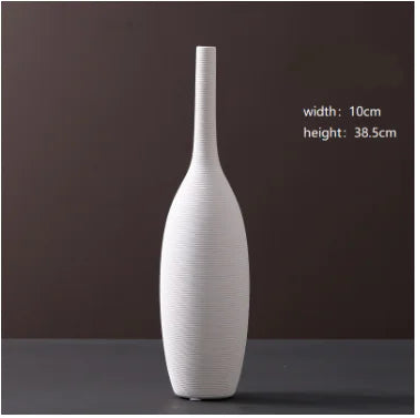 White ceramic vase on a dark surface with a brown background