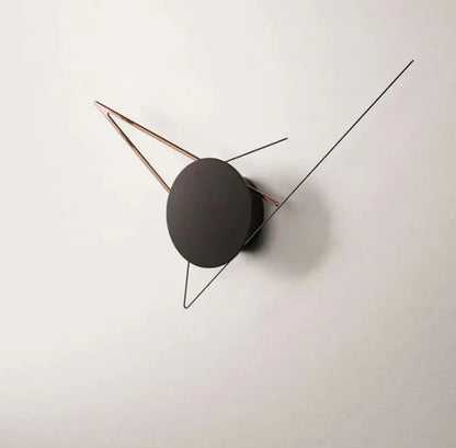 Modern wall clock with black round face and thin metallic arms on a white background