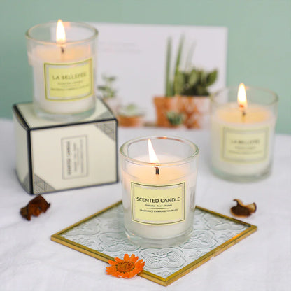 Three lit scented candles with visible labels on a decorative surface.